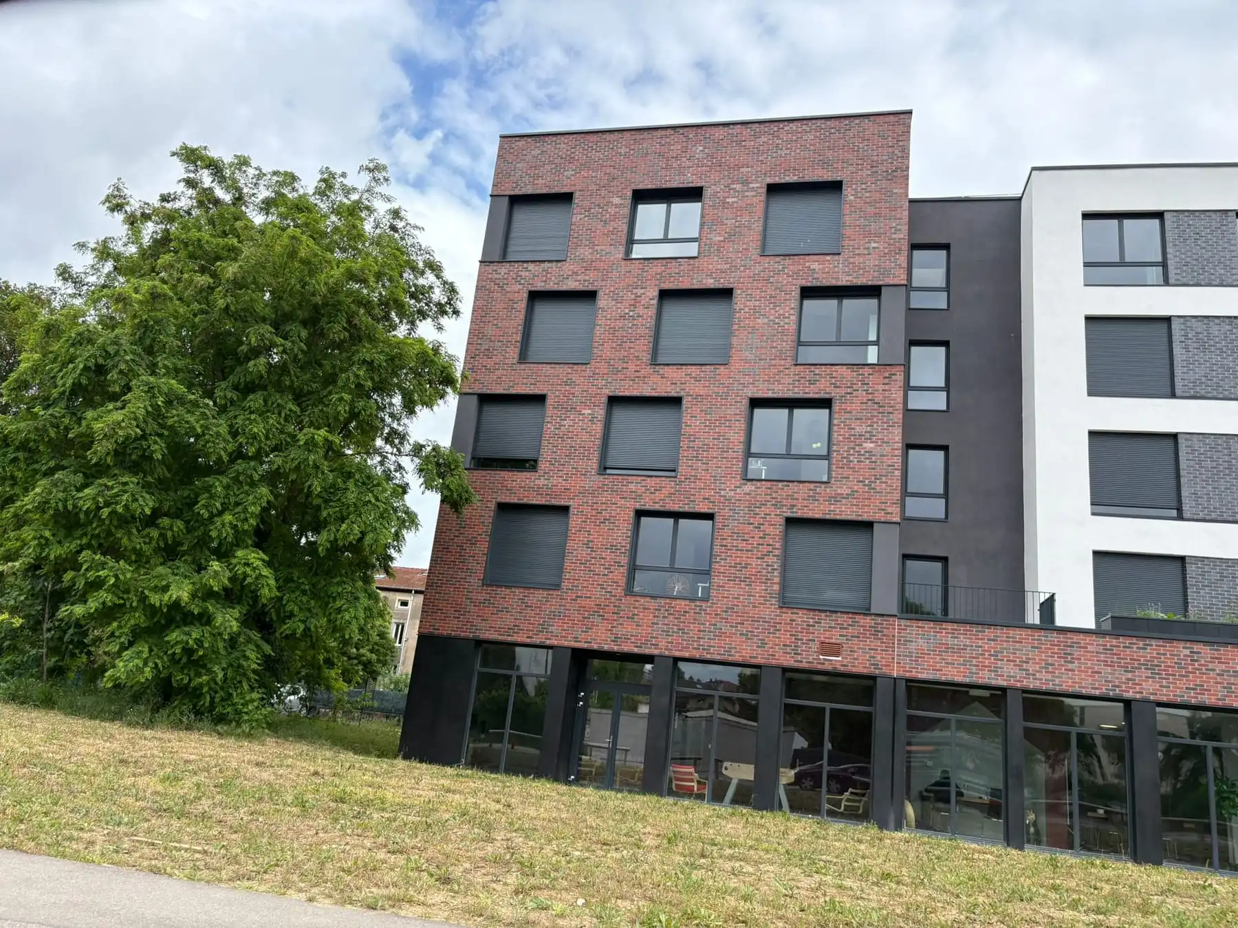 Façade d’un immeuble collectif habillée de briques de parement rouges et anthracite
