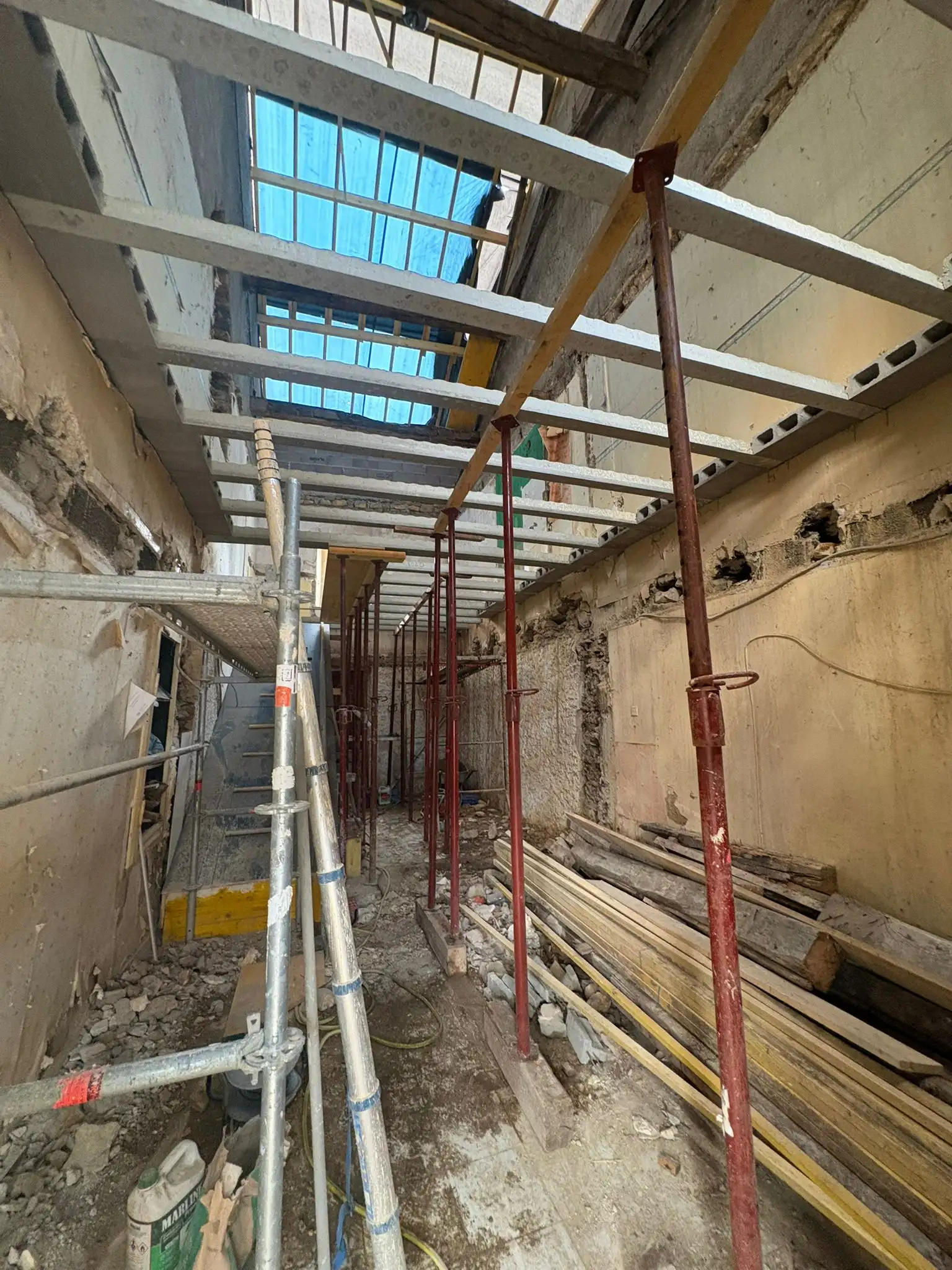 Façade sous échafaudage, avec étais posés pendant une reprise de structure sur une maison ancienne.